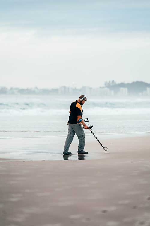 Man with scrap metal detector on Los Angeles beach